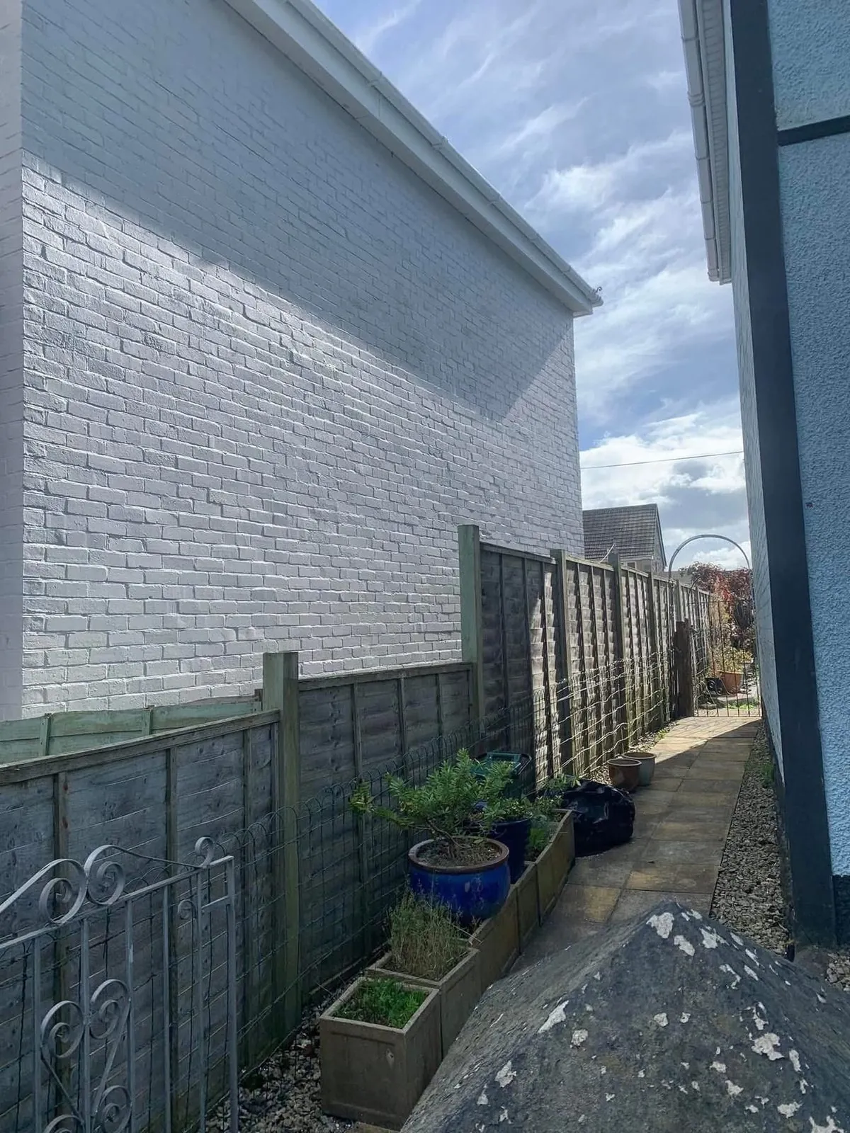 Freshly painted brick wall after preparation and masonry paint in Cullompton